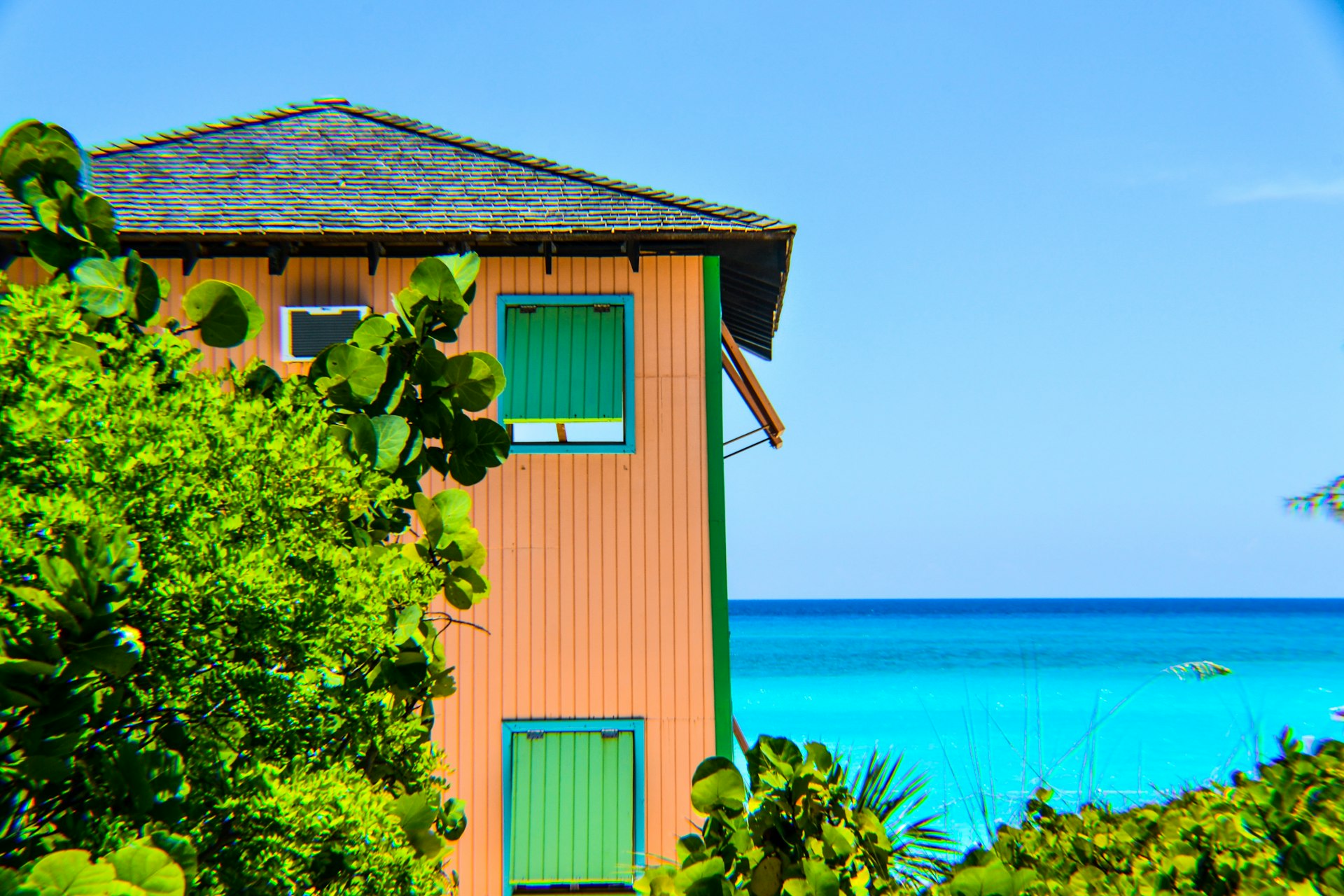 view of pink house near body of water
